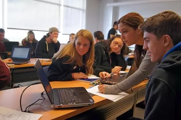 four students gathered around a computer